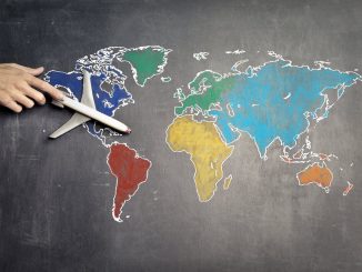 person with toy airplane on world map