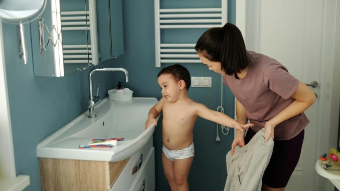 mother and son standing near the sink in the bathroom