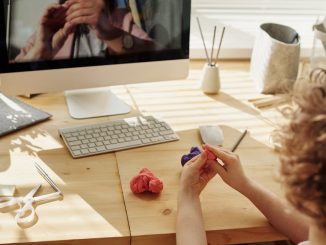 photo of kid playing with clay while looking in the monitor
